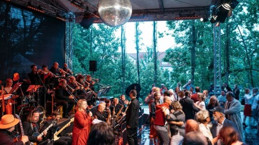 Die JENABIGBAND spielt auf der Bühne am Pappelsaal, währenddessen tanzen zahlreiche Paare zur Musik.